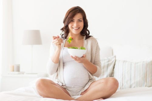 Pregnant woman with gestational diabetes eating a salad who is seeing one of our diabetes doctors In Idaho Falls or Pocatello.