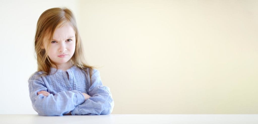 Young girl folding arms pouting with Prader-Willi Syndrome symptoms receiving treatment from Dr. Josua Smith, the region's only pediatric endocrinologist in Idaho Falls and Pocatello.
