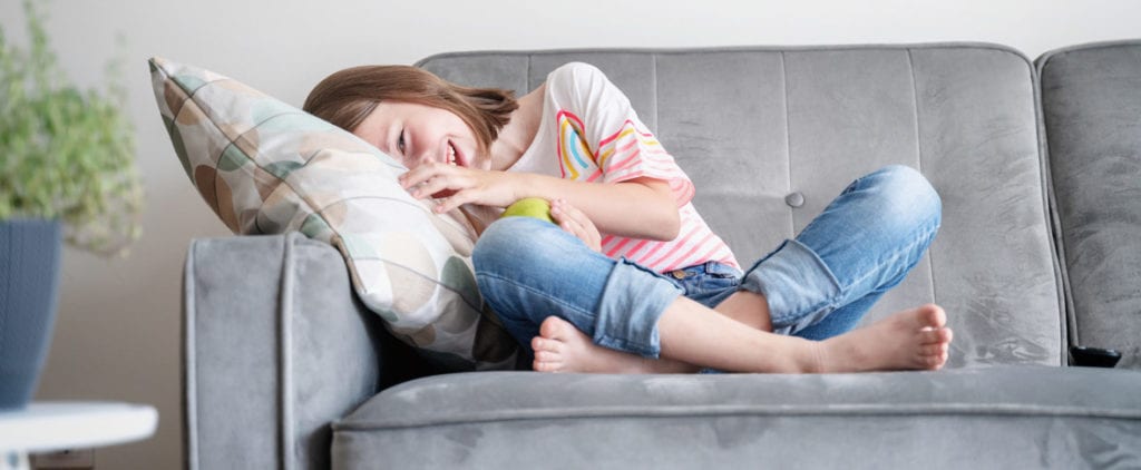 Smiling young girl on couch with Turner Syndrome issues receiving treatment from Dr. Josua Smith, the region's only pediatric endocrinologist in Idaho Falls and Pocatello.