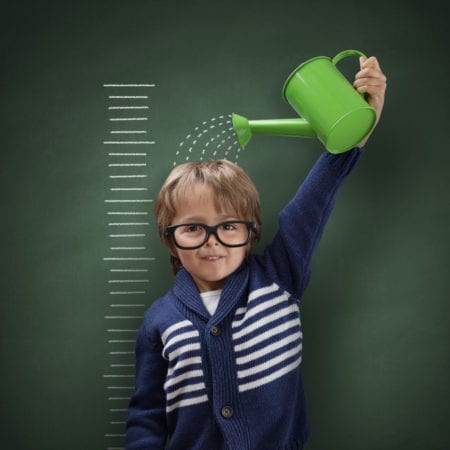 Young boy growing himself with watering can after a short stature treatment by Dr. Joshua Smith, a pediatric endocrinologist in Pocatello and Idaho Falls.