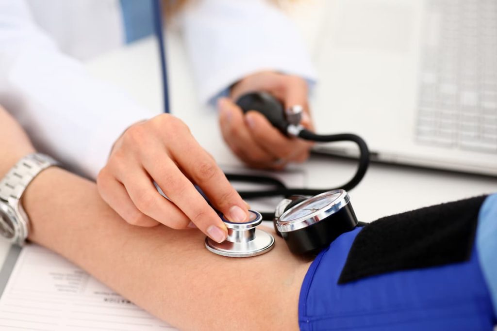Doctor taking patient's blood pressure and then treated for hypertention by our endocrinologists in Idaho Falls and Pocatello.