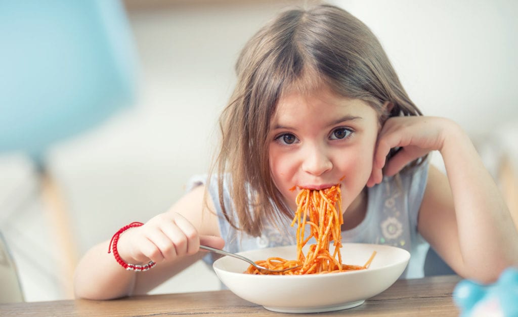 Girl eating spaghetti.