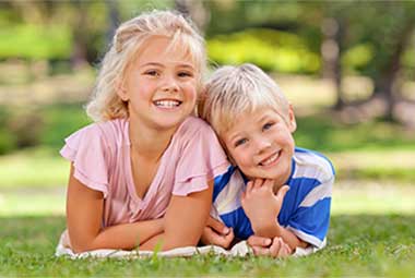 A boy and girls laying in a park, thinking about their pediatric endocrinologist caring for children with diabetes in Idaho Falls, Pocatello, Blackfoot and all of East Idaho.