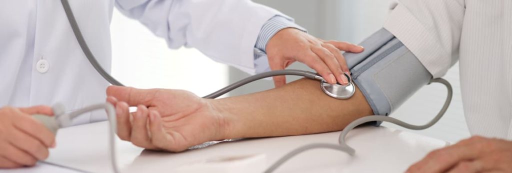 Doctor taking patient's blood pressure and then treated for hypertention by our endocrinologists in Idaho Falls and Pocatello.