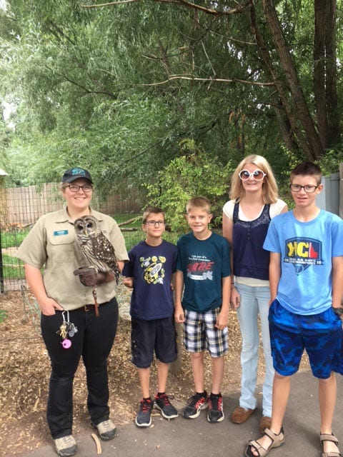 Group of kids next to a zoo employee holding an owl during diabetes fun day in Idaho Falls.