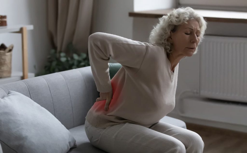 Senior woman with back pain caused by osteoporosis and needing to see our endocrinology specialist doctor in Idaho Falls and Pocatello.