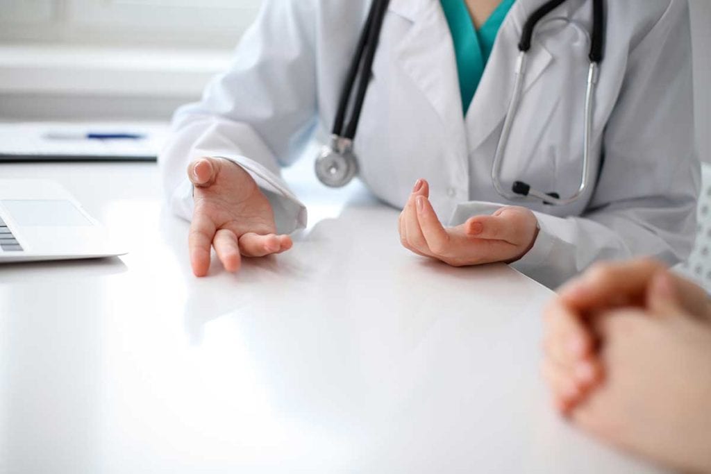 A diabetes doctor writing out a prescription for a patient to take to the pharmacy to be filled.