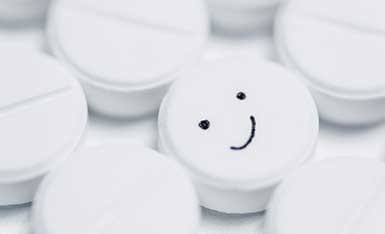 A few medication tablets, one with a smiley face.