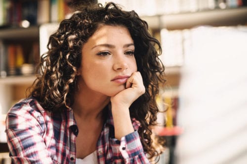 Young woman studying at a computer thinking about ovarian dysfunction treatments by Dr. Joshua Smith, a pediatric endocrinologist in Pocatello and Idaho Falls.
