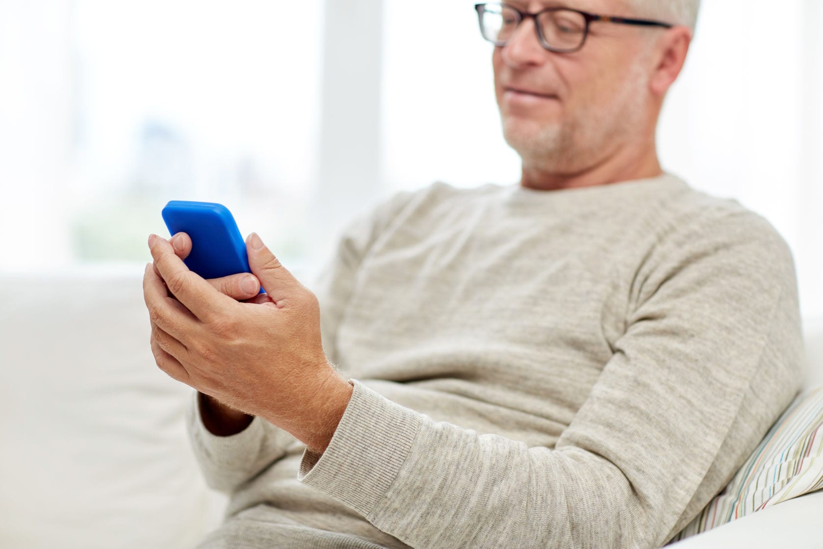 Man looking at cell phone regarding COVID-19 testing.