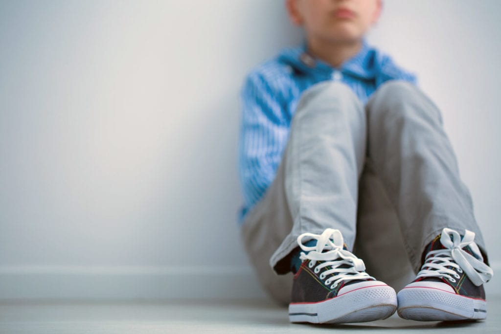 Tired boy sitting on floor concerned about his vitamin d deficiencies but getting treatment from Dr. Josua Smith, the region's only pediatric endocrinologist in Idaho Falls and Pocatello.
