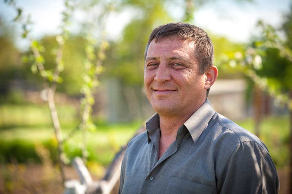 Smiling middle aged man in his back yard, smiling into the camera because he has a diabetes doctor at Rocky Mountain Diabetes in Idaho Falls and Pocatello.