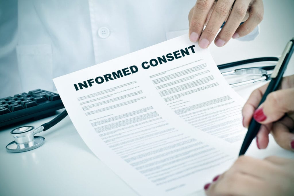 A clinical research staff member showing a patient an Informed Consent document that is part of a clinical study within our endocrine specialty and diabetes doctor care in Idaho Falls and Pocatello.
