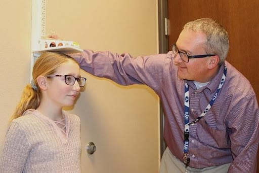 Dr Josh measuring the height of a young girl.